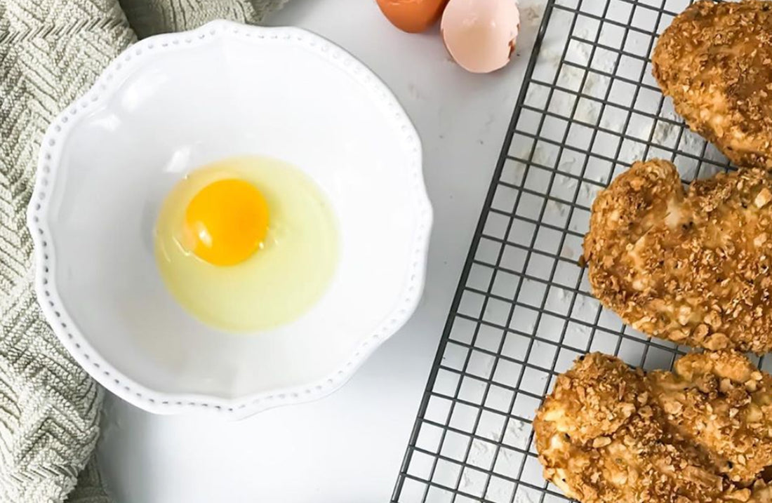 Coconut Crusted Chicken next to bowl with egg in it. 